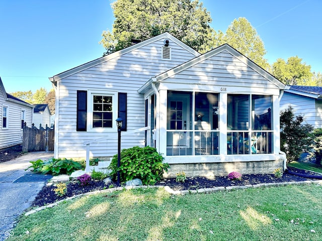 bungalow-style house featuring a front lawn and a sunroom