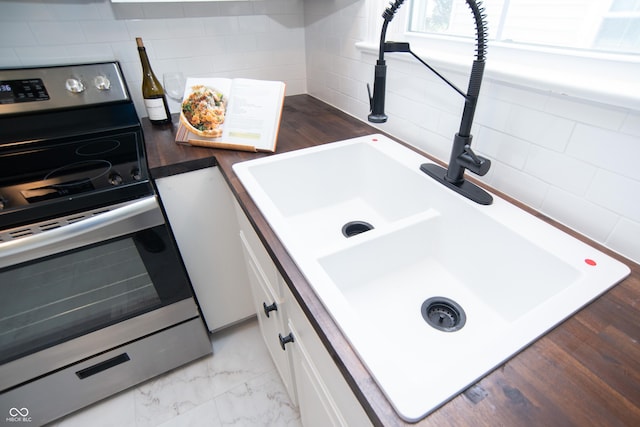 kitchen featuring sink, white cabinets, and stainless steel electric range oven