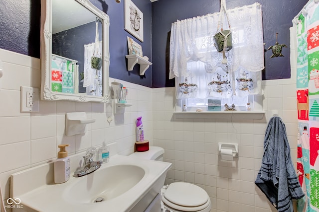 bathroom featuring vanity, toilet, and tile walls