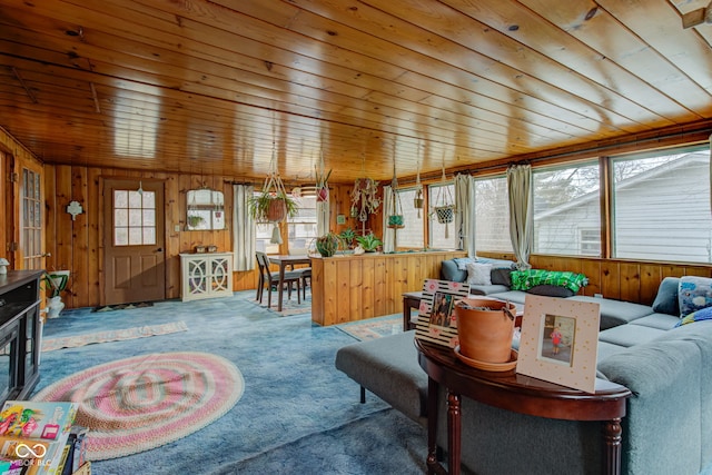 living room with wooden walls, wooden ceiling, and carpet flooring