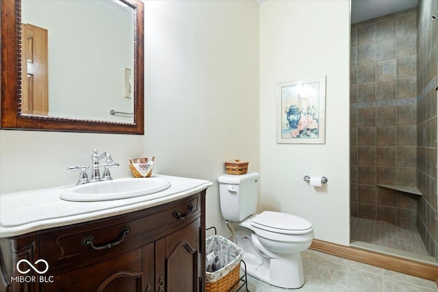 bathroom featuring tile patterned floors, toilet, vanity, and a tile shower