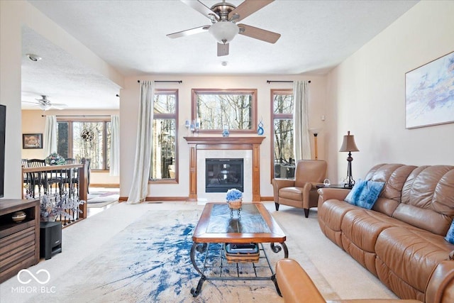 living area featuring carpet flooring, a healthy amount of sunlight, and a ceiling fan