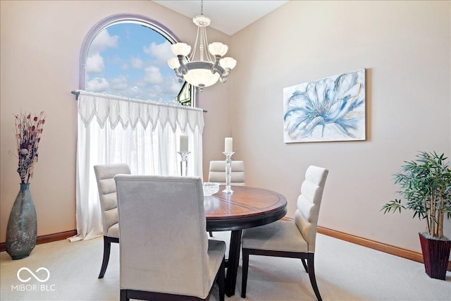 dining space with a notable chandelier, light colored carpet, a high ceiling, and baseboards