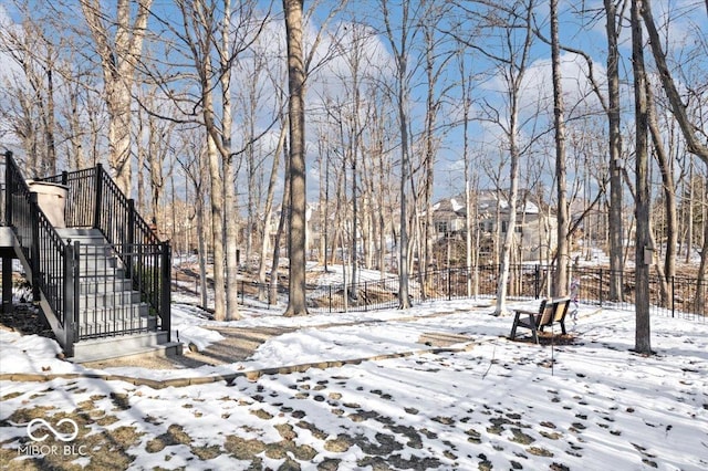 snowy yard with stairs and fence