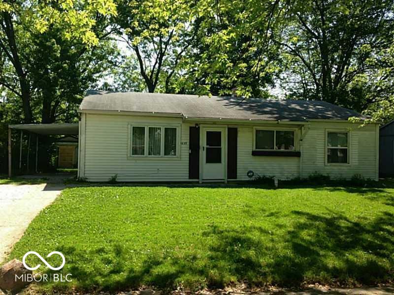 ranch-style home with a front yard, concrete driveway, and a carport