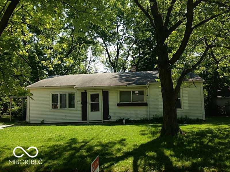 single story home with a chimney and a front yard