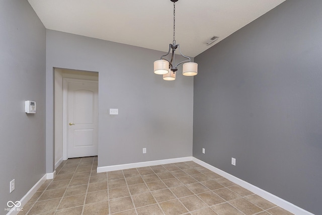 tiled spare room featuring a notable chandelier