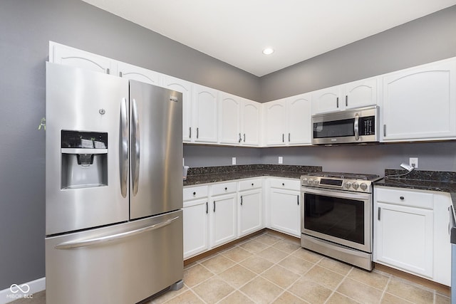 kitchen with dark stone counters, white cabinets, and appliances with stainless steel finishes