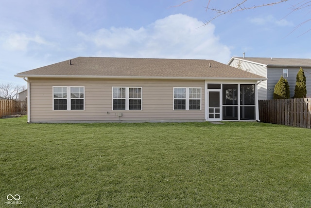 back of property with a sunroom and a lawn