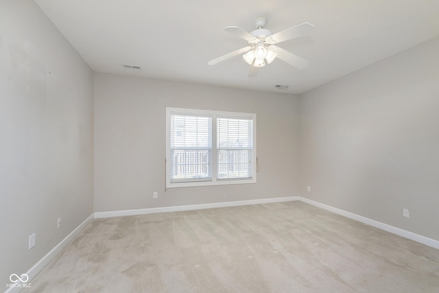 carpeted spare room with ceiling fan