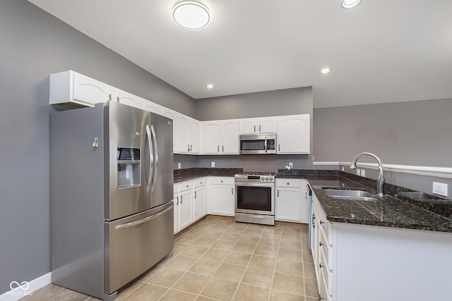 kitchen with white cabinetry, sink, light tile patterned floors, and stainless steel appliances