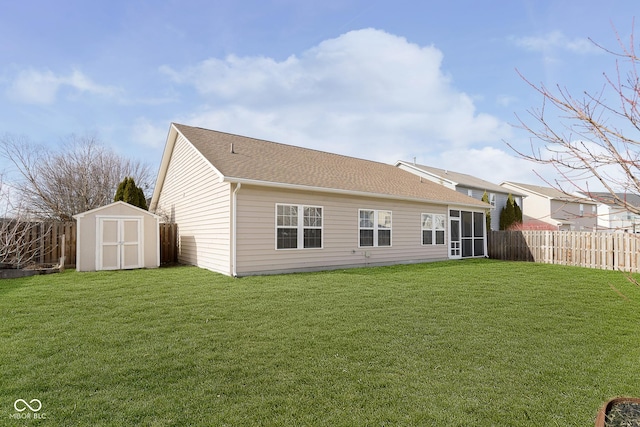 rear view of property featuring a yard and a storage unit