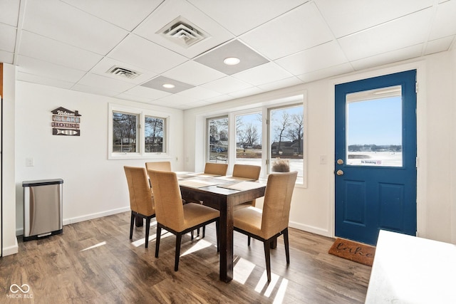 dining area featuring dark hardwood / wood-style floors and a paneled ceiling