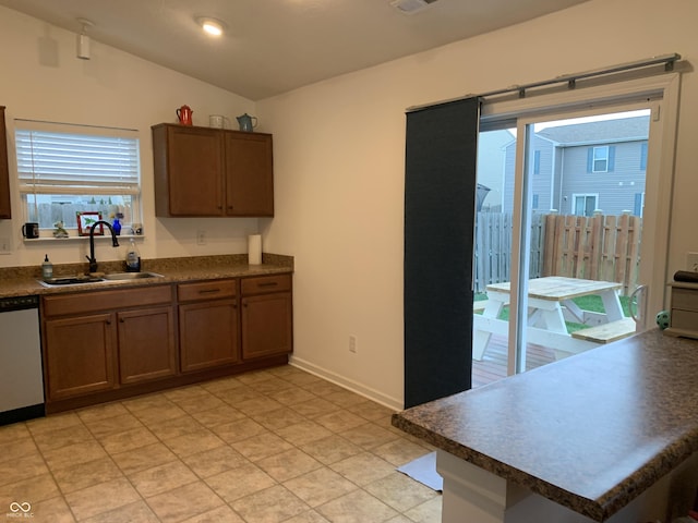 kitchen with sink, vaulted ceiling, and dishwasher