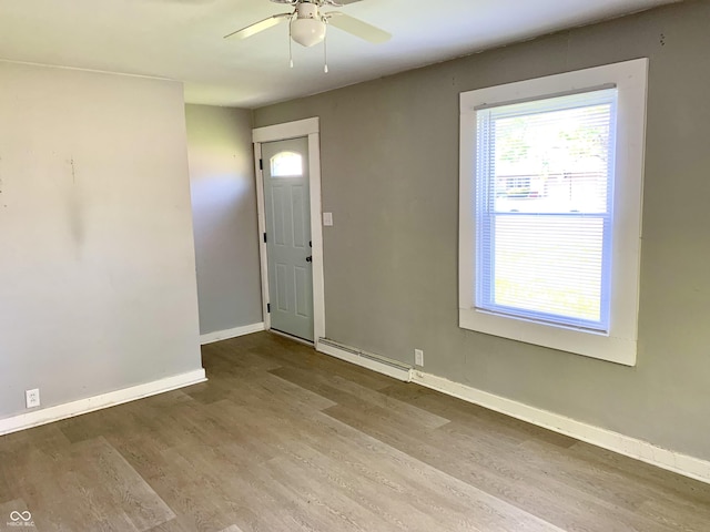 foyer entrance featuring a baseboard heating unit, hardwood / wood-style flooring, and ceiling fan