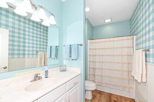 full bathroom with shower / tub combo with curtain, wood-type flooring, toilet, and vanity