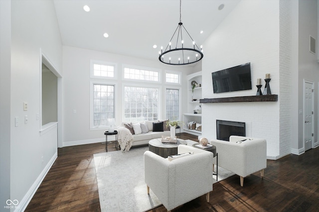 living room with built in shelves, dark hardwood / wood-style floors, high vaulted ceiling, and a brick fireplace