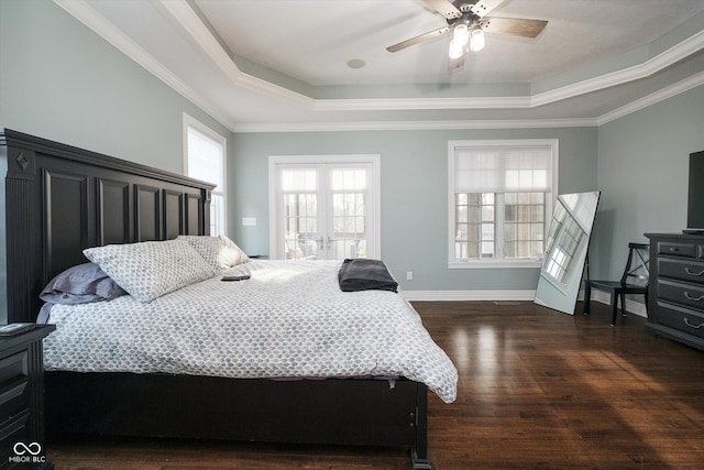 bedroom featuring crown molding, a tray ceiling, dark hardwood / wood-style floors, and french doors