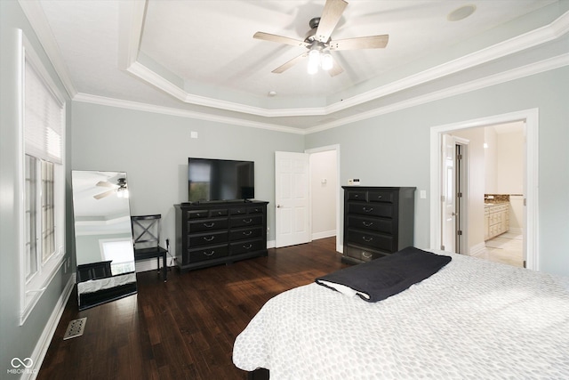 bedroom with dark hardwood / wood-style flooring, a tray ceiling, multiple windows, and ornamental molding