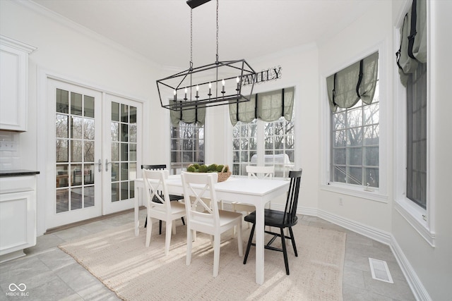 dining space featuring ornamental molding, a notable chandelier, and french doors