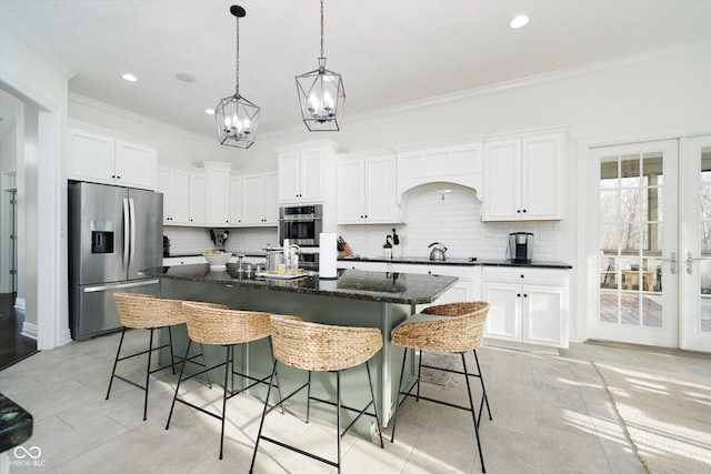 kitchen with white cabinetry, a center island with sink, a kitchen breakfast bar, and appliances with stainless steel finishes