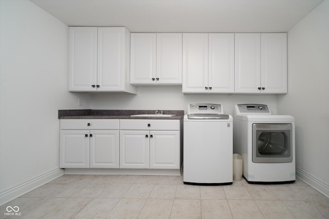 washroom featuring cabinets, sink, and washing machine and clothes dryer