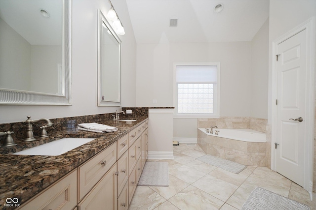 bathroom featuring vanity and tiled bath