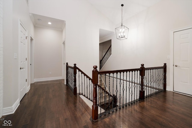 stairway featuring vaulted ceiling, crown molding, hardwood / wood-style floors, and a chandelier