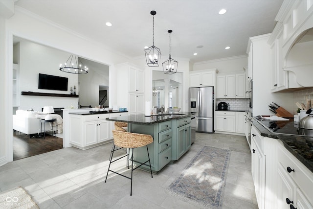 kitchen featuring pendant lighting, stainless steel fridge, a kitchen breakfast bar, a center island, and white cabinets