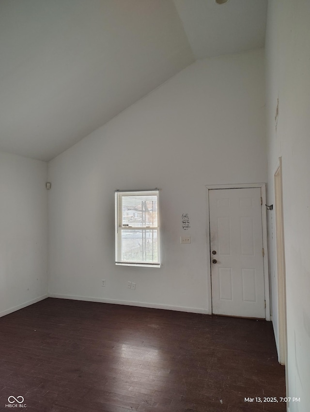 interior space with baseboards, high vaulted ceiling, and wood finished floors