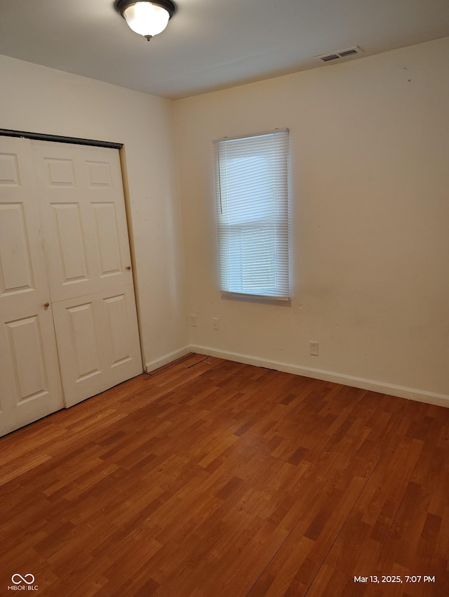 unfurnished bedroom featuring a closet, visible vents, baseboards, and light wood-style floors