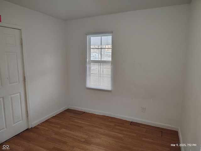 unfurnished room featuring baseboards and wood finished floors