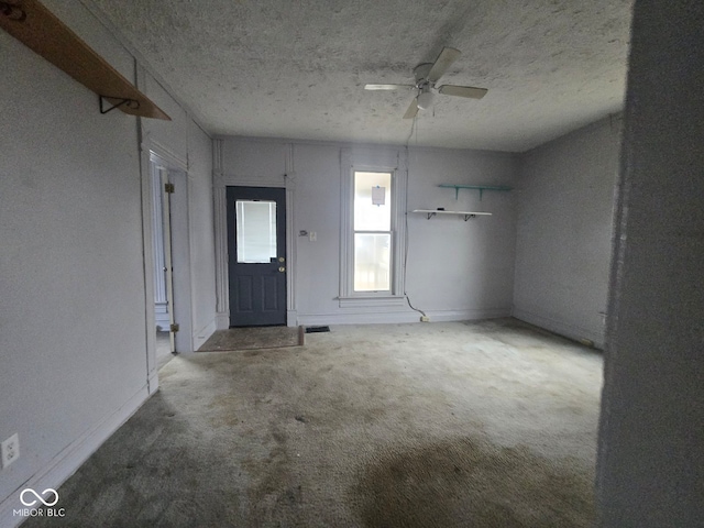 interior space with ceiling fan and a textured ceiling