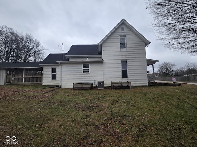 back of property featuring central AC unit and a lawn