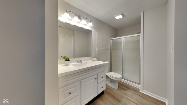 bathroom featuring vanity, wood-type flooring, toilet, and walk in shower