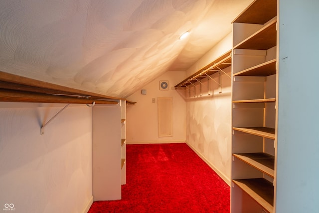 walk in closet featuring lofted ceiling and carpet floors