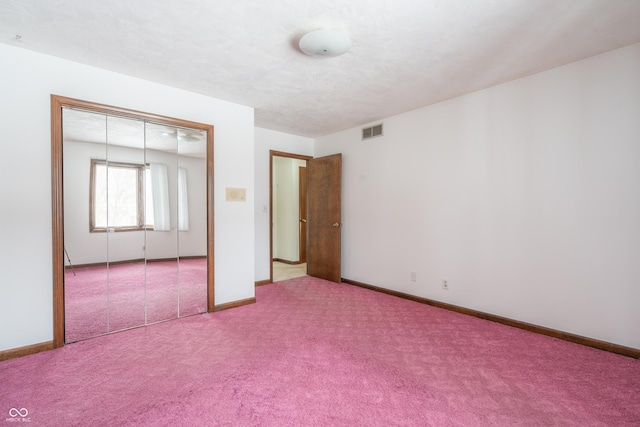 unfurnished bedroom featuring a closet, a textured ceiling, and carpet