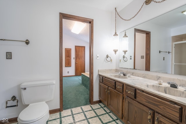 bathroom featuring vanity, vaulted ceiling, and toilet