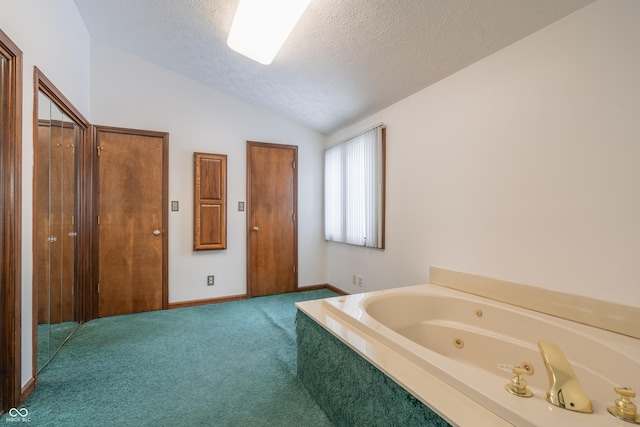 bathroom with vaulted ceiling, a textured ceiling, and a washtub