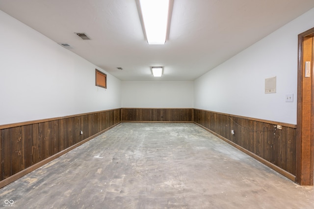 spare room featuring wooden walls