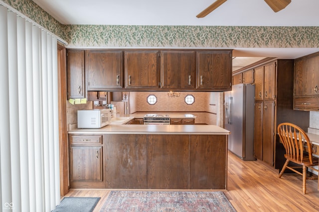 kitchen featuring sink, light wood-type flooring, appliances with stainless steel finishes, kitchen peninsula, and ceiling fan