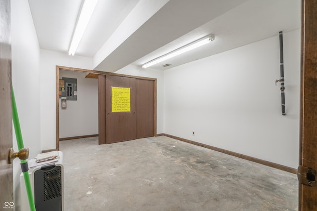 interior space with heating unit, concrete flooring, and electric panel