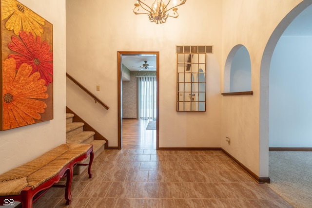 corridor featuring a notable chandelier and a high ceiling