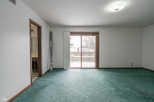 unfurnished room featuring carpet and a textured ceiling