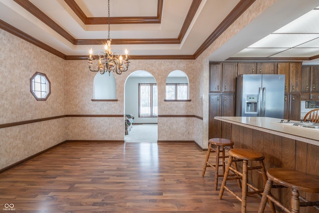 interior space featuring crown molding, a chandelier, dark hardwood / wood-style floors, and a raised ceiling