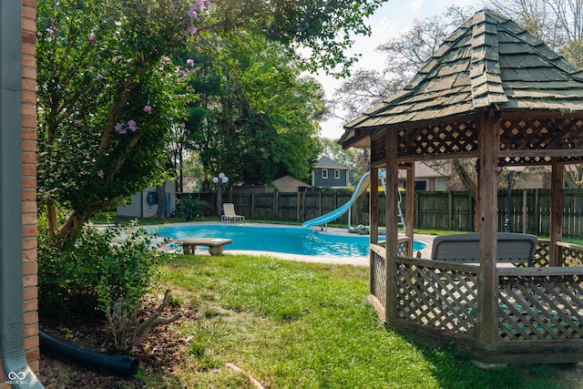 view of swimming pool featuring a yard, a gazebo, and a water slide