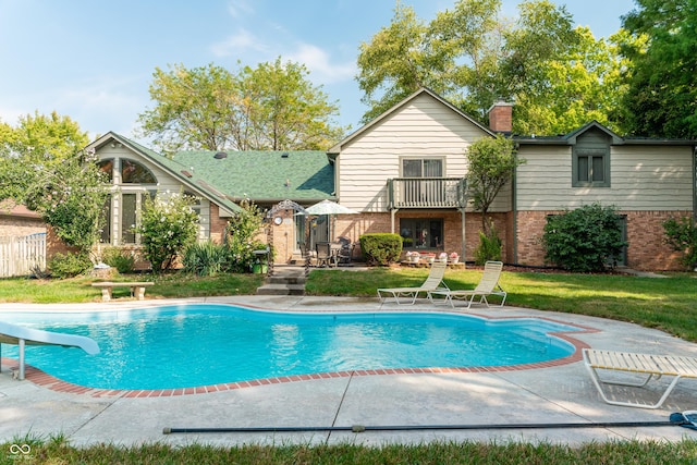 view of pool featuring a yard, a patio, and a water slide