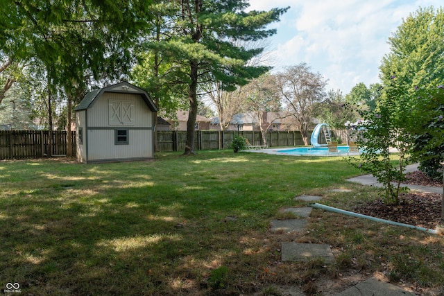 view of yard featuring a storage shed and a fenced in pool