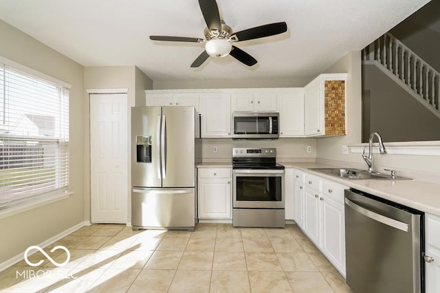 kitchen with sink, ceiling fan, white cabinetry, stainless steel appliances, and light tile patterned flooring