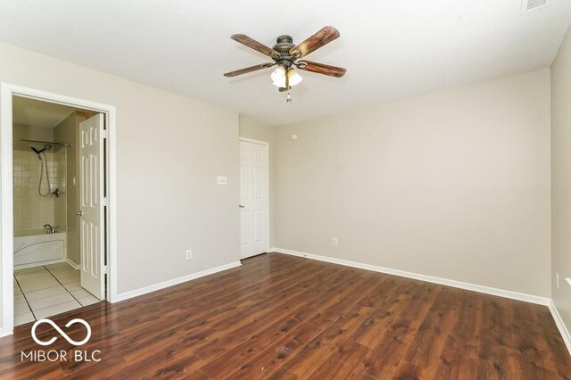 unfurnished bedroom with ceiling fan, connected bathroom, and dark hardwood / wood-style flooring